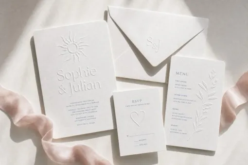 Visualisation: a cream wedding suite, invitation with a sun motif, monogrammed envelope, RSVP card and menu, blind embossed on white cotton paper.